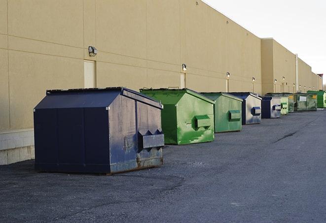 a row of yellow and blue dumpsters at a construction site in Auburn KS